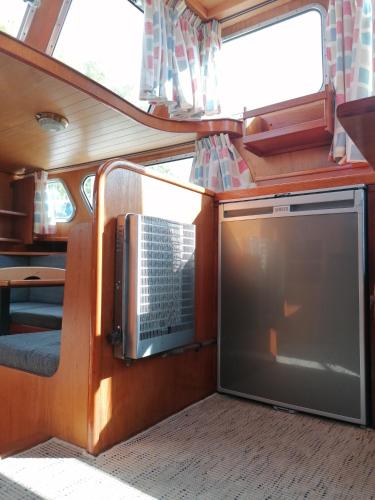 une vue intérieure d'un wagon de train avec une télévision dans l'établissement Logement insolite, Péniche Hollandaise, à Cognac