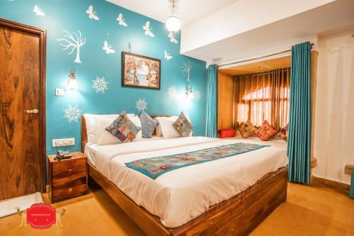 a bedroom with a large bed with blue walls at Hotel Golden Legacy - by PRAMANA EXP in Jaisalmer