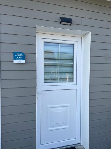 une porte blanche avec une fenêtre sur une maison dans l'établissement Je m'y plais, à Sainte-Marguerite