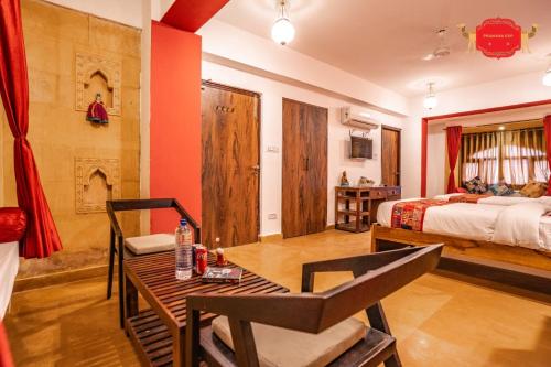 a hotel room with a bed and a table and a bed at Hotel Golden Legacy - by PRAMANA EXP in Jaisalmer