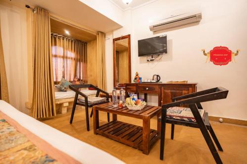 a living room with a table and chairs and a television at Hotel Golden Legacy - by PRAMANA EXP in Jaisalmer