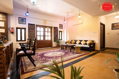 a living room with a couch and a table at Hotel Golden Legacy - by PRAMANA EXP in Jaisalmer
