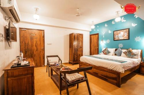 a bedroom with a bed and a table in a room at Hotel Golden Legacy - by PRAMANA EXP in Jaisalmer