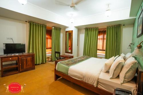 a bedroom with a bed and a flat screen tv at Hotel Golden Legacy - by PRAMANA EXP in Jaisalmer