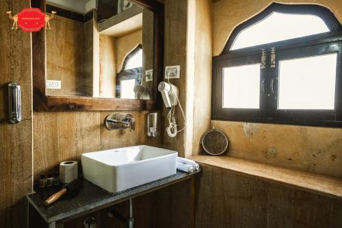 a bathroom with a white sink and a window at Hotel Golden Legacy - by PRAMANA EXP in Jaisalmer