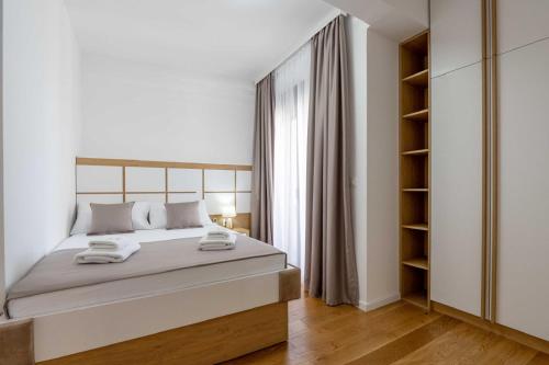 a white bedroom with a large bed and a closet at Apartments BB in Becici