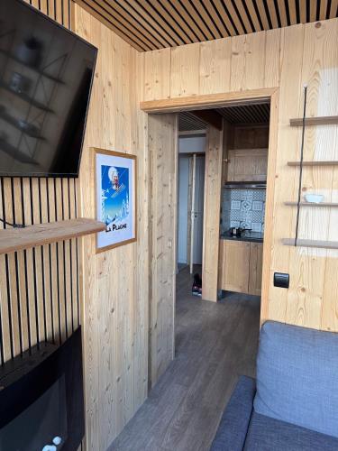 un salon avec une grande télévision à écran plat sur un mur dans l'établissement Magnifique appartement 4-6 personnes au pied des pistes à La Plagne Centre, à La Plagne Tarentaise