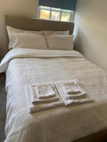 a bed with white towels and pillows on it at Listed building close to River Thames in London