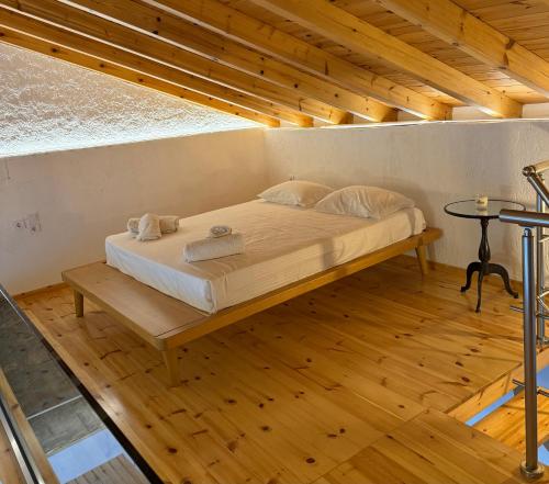 una cama en una habitación con techo de madera en Michalelis Loft & Cave, en Plomari