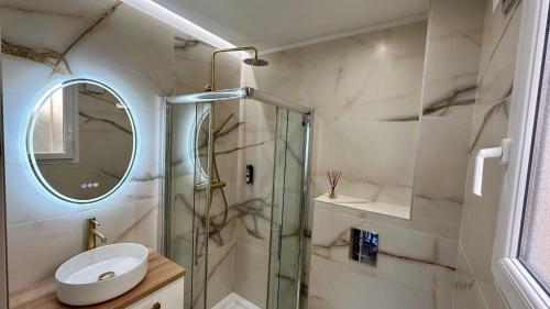 une salle de bain avec une douche, un lavabo et un miroir dans l'établissement Charmant studio climatisé, proche de la plage, à San-Martino-di-Lota