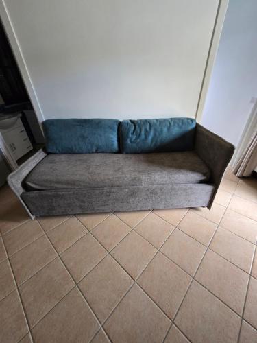a blue couch sitting in a room with a tile floor at Dimora Kalipè in Bevagna