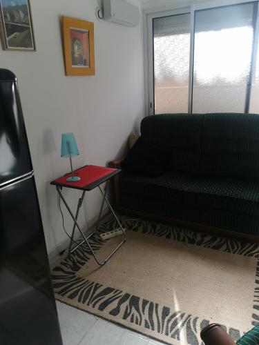 - un salon avec un canapé noir et une table rouge dans l'établissement Mer et montagne, à Perpignan