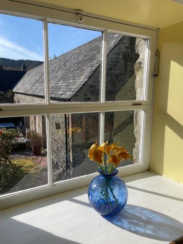 a blue vase sitting on a window sill with a flower at The Steading at Barmore in Tarbert