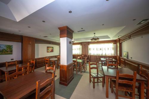 a dining room with wooden tables and chairs at Hotel Ramses Ks in Golem