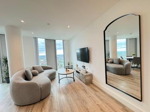 a living room with a large mirror and a couch at 3 Bedroom Penthouse In The City Centre Deansgate New Build High Floor in Manchester