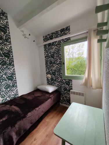 a small bedroom with a bed and a window at Village Bord de Ciel in Caylus