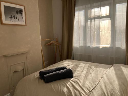a bed with two towels on it in front of a window at Base in the Black Country, 4 Beds & Large Drive in Brownhills