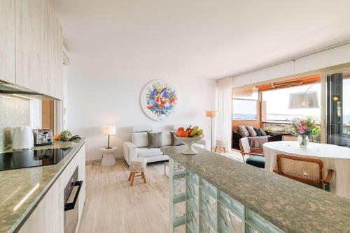 a kitchen and living room with a counter and a couch at Emilie - panoramic sea views beach facing paradise in Vallauris