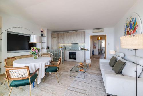 a living room with a white couch and a table at Emilie - panoramic sea views beach facing paradise in Vallauris
