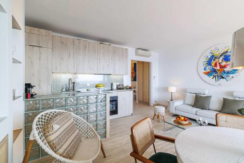 a kitchen and living room with a table and chairs at Emilie - panoramic sea views beach facing paradise in Vallauris