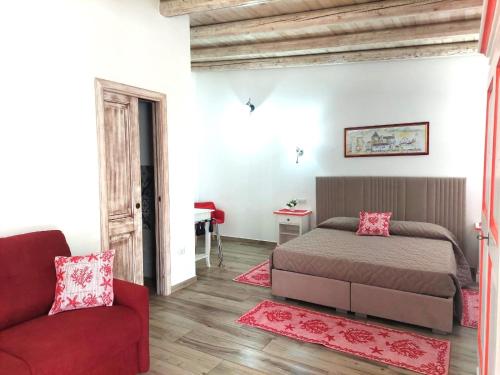 a bedroom with a bed and a red couch at Sisula Country Hotel & SPA in Orosei