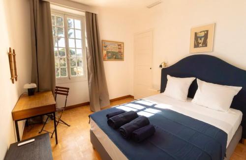 une chambre avec un grand lit et un bureau dans l'établissement La Roca Blanca, à Cassis