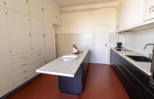 - une cuisine avec des placards blancs et un comptoir avec un évier dans l'établissement La Roca Blanca, à Cassis