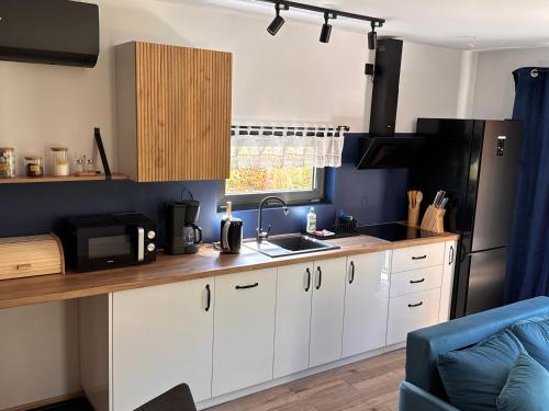 a kitchen with white cabinets and a black refrigerator at Forest Mood in Wieck