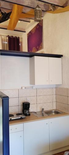 a kitchen with white cabinets and a sink at Village Bord de Ciel in Caylus