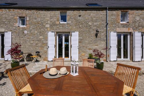 a wooden table with hats on it in front of a building at Les 13 lavoirs d'antan - chambre la belle époque in Saint-Pierre-Église