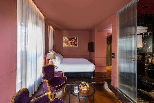a hotel room with a bed and a table and chairs at Casa Suzanna Hotel Tel-Aviv קאסה סוזנה נחלת בנימין in Tel Aviv