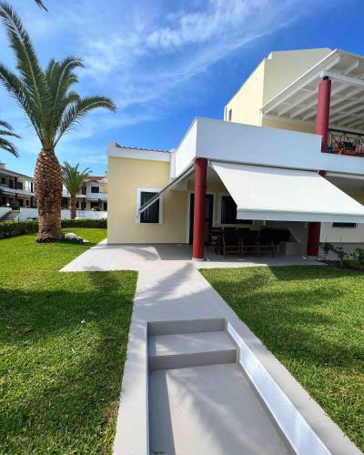 ein Haus mit einer Bank davor in der Unterkunft Casa di Palma Beach Front in Pefkohori