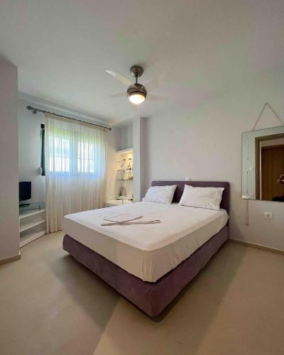 ein Schlafzimmer mit einem großen Bett und einem Deckenventilator in der Unterkunft Casa di Palma Beach Front in Pefkohori