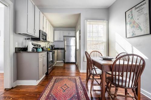 eine Küche mit Tisch und Stühlen und einem Kühlschrank in der Unterkunft HISTORIC DOWNTOWN KING BED COTTAGE- PARKING and PATIO in Savannah