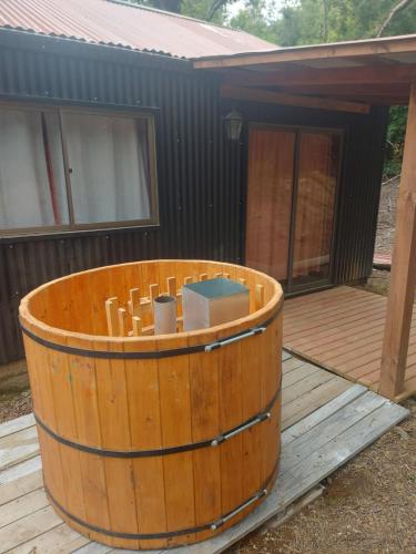 a wooden hot tub sitting on a deck at Cafeteria y Cabañas Eluney - Llaurel in Pucón