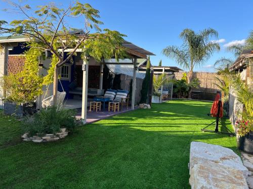 einen Hof mit grünem Gras und einem Haus in der Unterkunft פרא בקתות אירוח in Nir Yafe