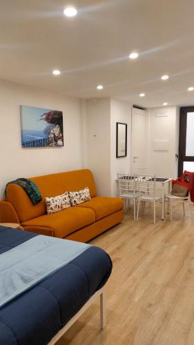 a living room with an orange couch and a table at Casa Nina in Amalfi