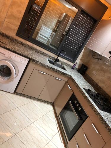 eine Küche mit Spüle und Waschmaschine in der Unterkunft Appartement cosy 1er étage in Kenitra