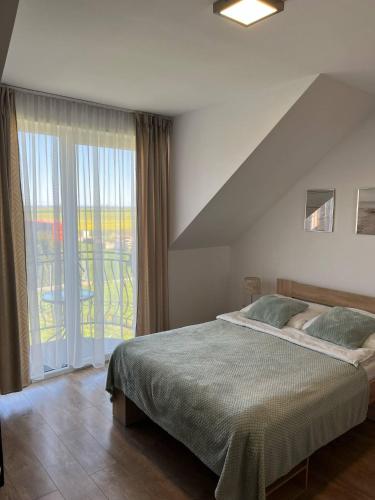 a bedroom with a bed and a large window at Willa Arkadia w Pucku in Puck