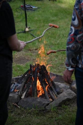 a person cooking hot dogs over a fire at Apartamenty Monika SPA i Agroturystyka in Korbielów