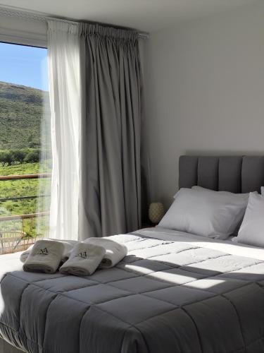 a bedroom with a bed with a large window at Pie de Piedra Hotel Boutique in Sierra de la Ventana