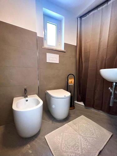 a bathroom with a white toilet and a sink at La casa dell'Artemisia in Cefalù