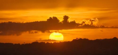 an orange sunset with the sun in the clouds at Appartements Des Roses in Le Lamentin