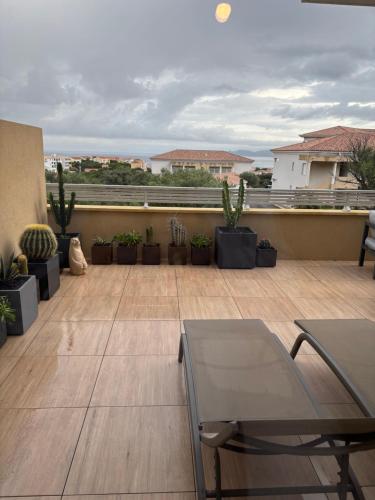 d'un balcon avec une table, des chaises et des plantes. dans l'établissement Île Rousse - Vue mer, à La Celle-sous-Gouzon