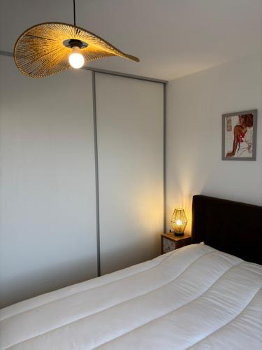 une chambre avec un lit blanc avec une grande fenêtre dans l'établissement Île Rousse - Vue mer, à La Celle-sous-Gouzon