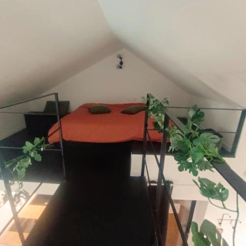 une chambre avec un lit avec une couverture rouge dans l'établissement Terre Sauvage Baie de Somme, à Abbeville