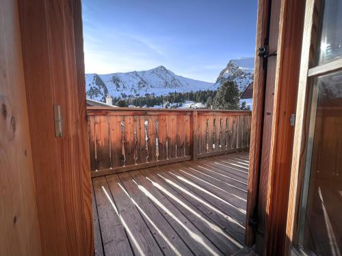 an open door to a deck with snow covered mountains at Almhütte Falkert in Patergassen