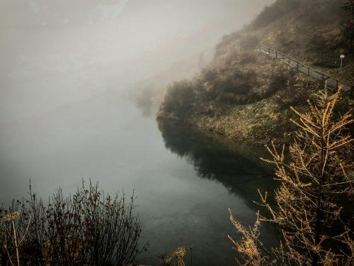 a misty river in the middle of a valley at Almhütte Falkert in Patergassen