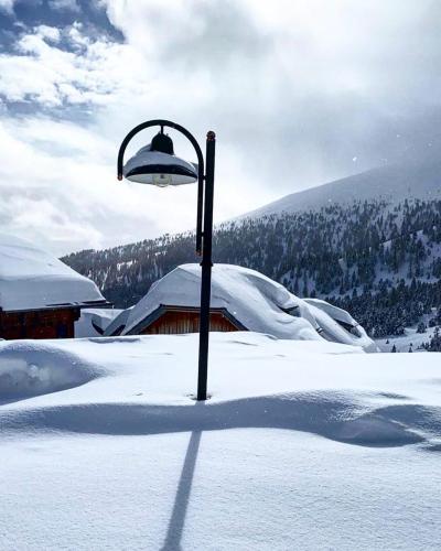 a street light in the snow with a building at Almhütte Falkert in Patergassen