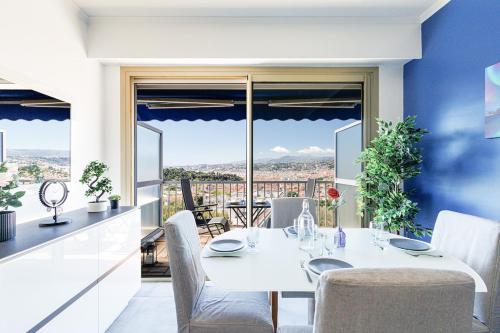 - une table et des chaises blanches dans la cuisine avec vue dans l'établissement Casa Nissa Blue, à Nice